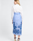 Woman modeling a white shirt and blue floral skirt on a white background