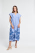 Woman wearing a blue caftan with floral embroidery on a white background
