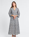 Woman wearing a black and white floral v-neck dress on a white background