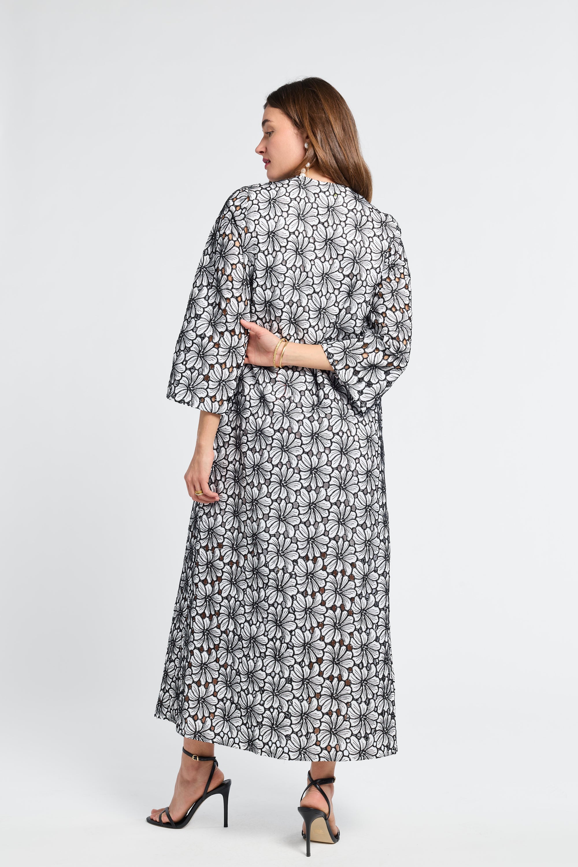 Woman wearing an embroidered floral dress on a white background