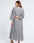 Woman wearing an embroidered floral dress on a white background