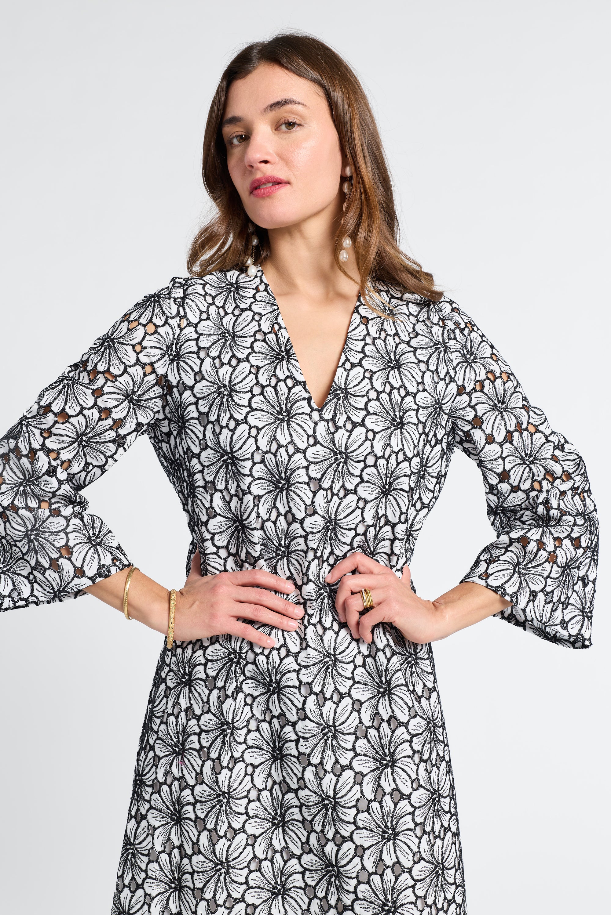 Woman wearing a black and white floral caftan on a white background