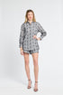 Woman wearing a black and white floral blouse on a white background