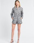 Woman wearing black and white floral shorts and black heels on a white background