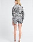 Woman wearing black and white patterned shorts and heels on a white background