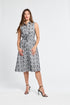 Woman wearing a sleeveless black and white floral dress on a white background