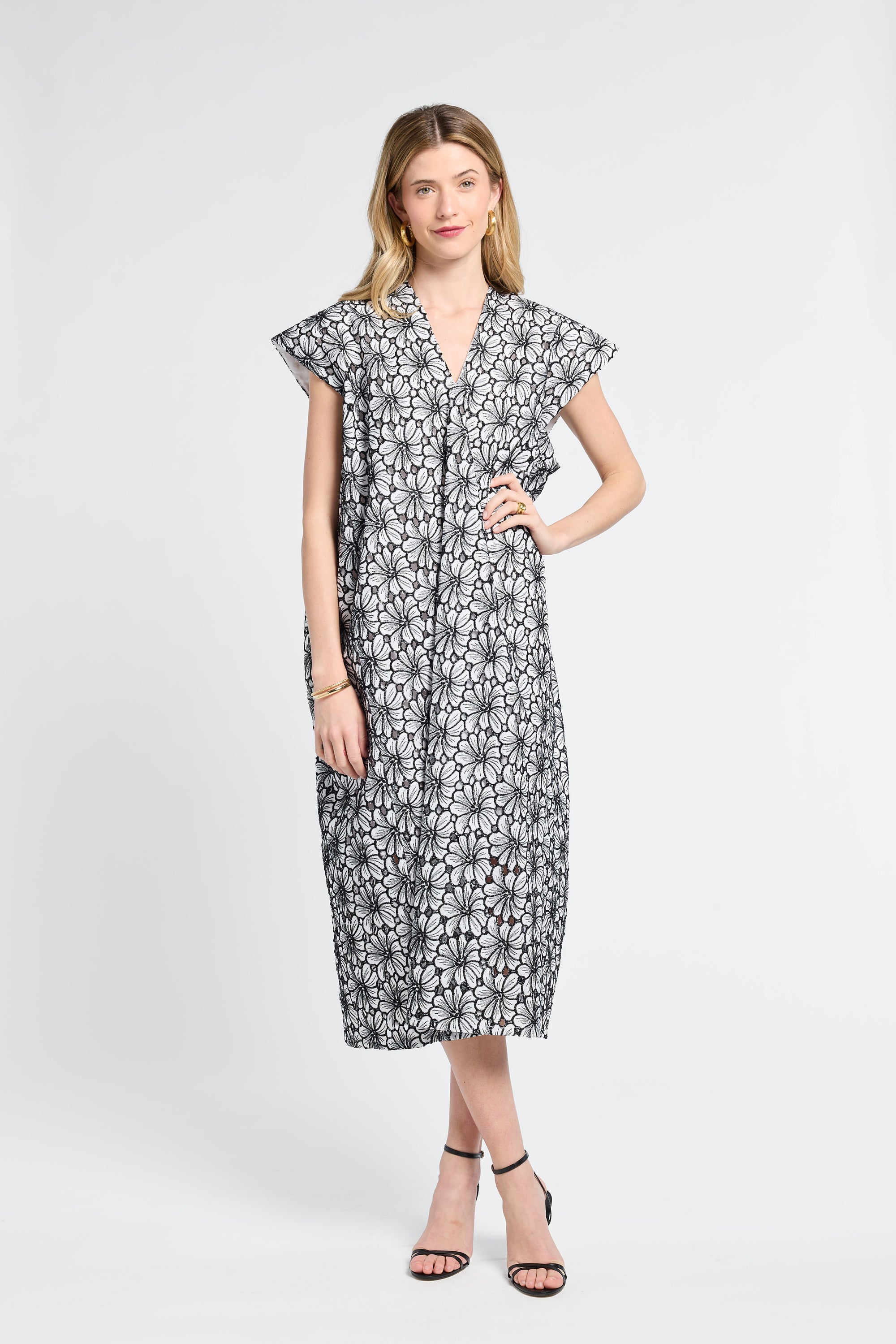 Woman wearing a black and white floral caftan on a white background