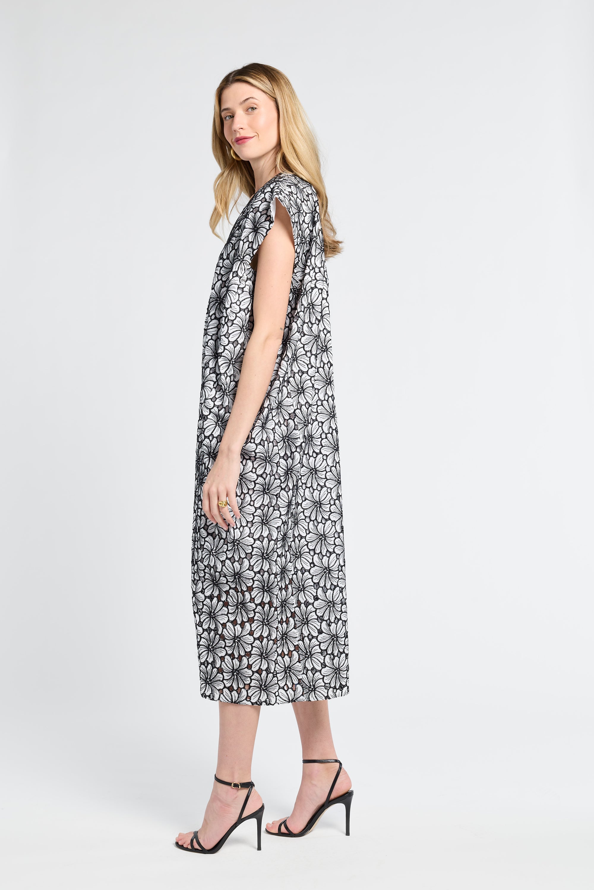 Woman wearing a black and white floral maxi dress against a white backdrop