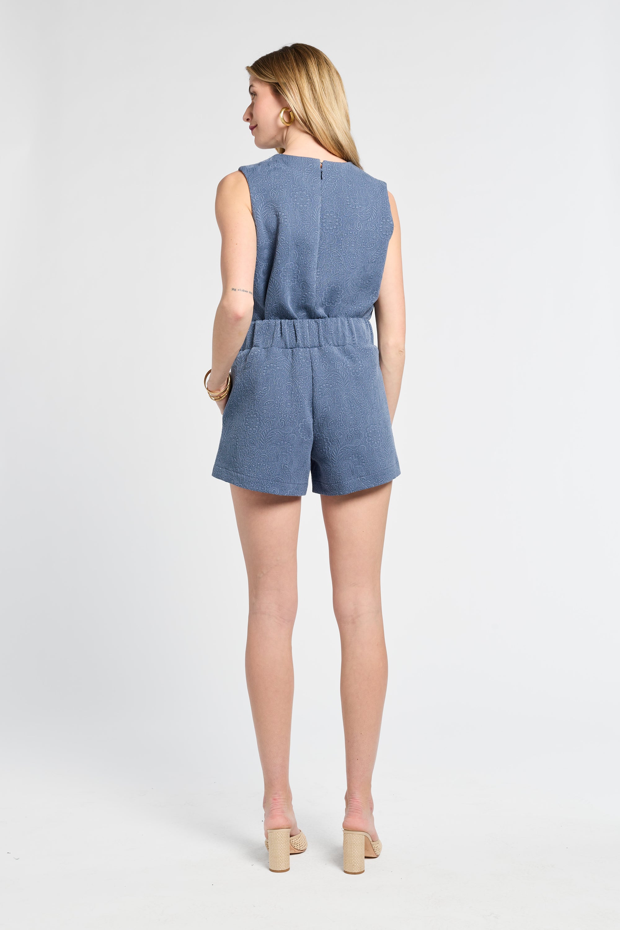 Woman wearing a pair of blue floral shorts on a white background