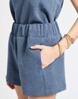 Blue patterned shorts modeled by a person on a light gray background
