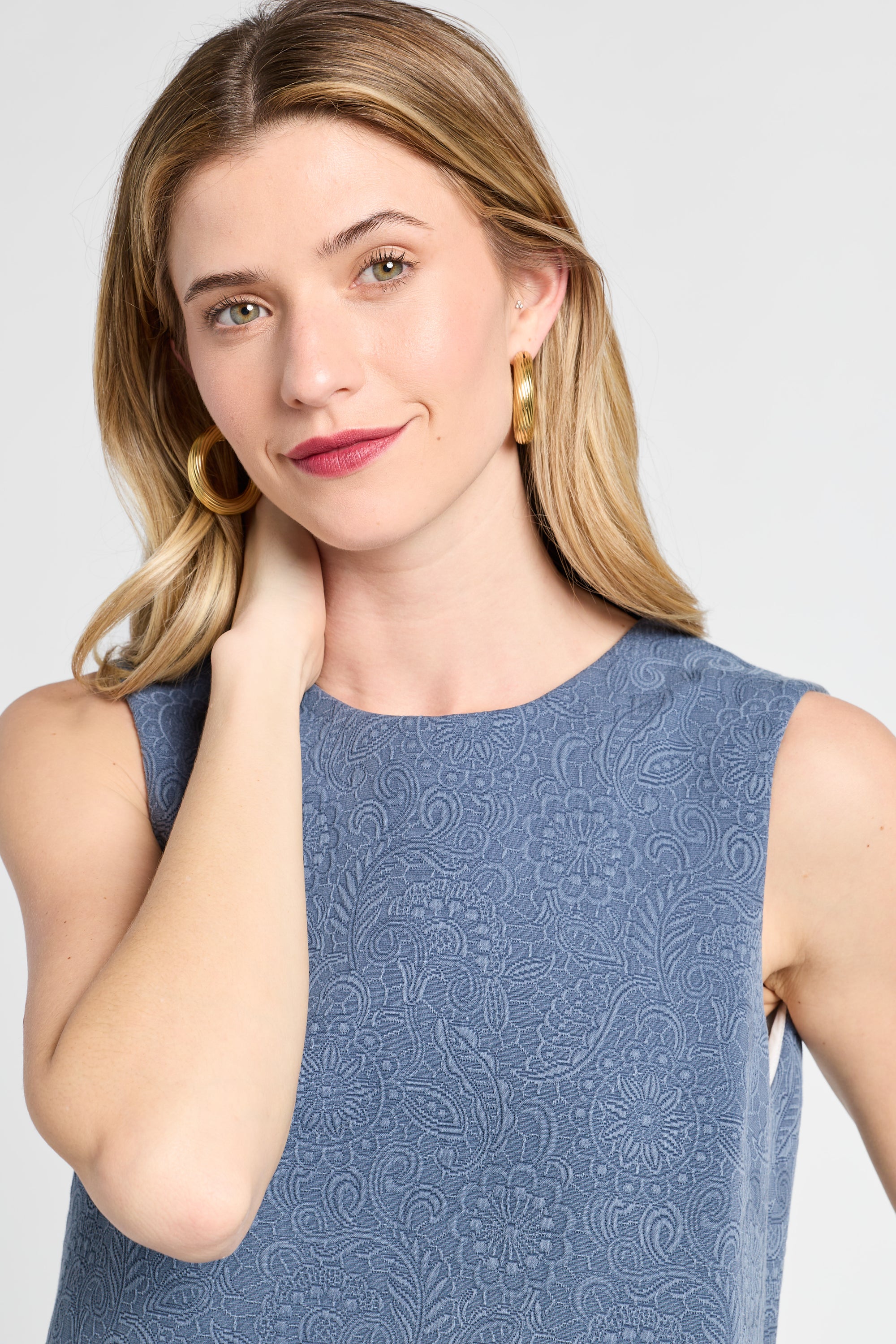 Woman wearing a blue patterned dress against a white background