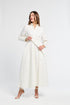 Woman wearing a white long sleeve dress on a white background