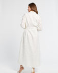 Woman with brown hair wearing a white dress against a white background