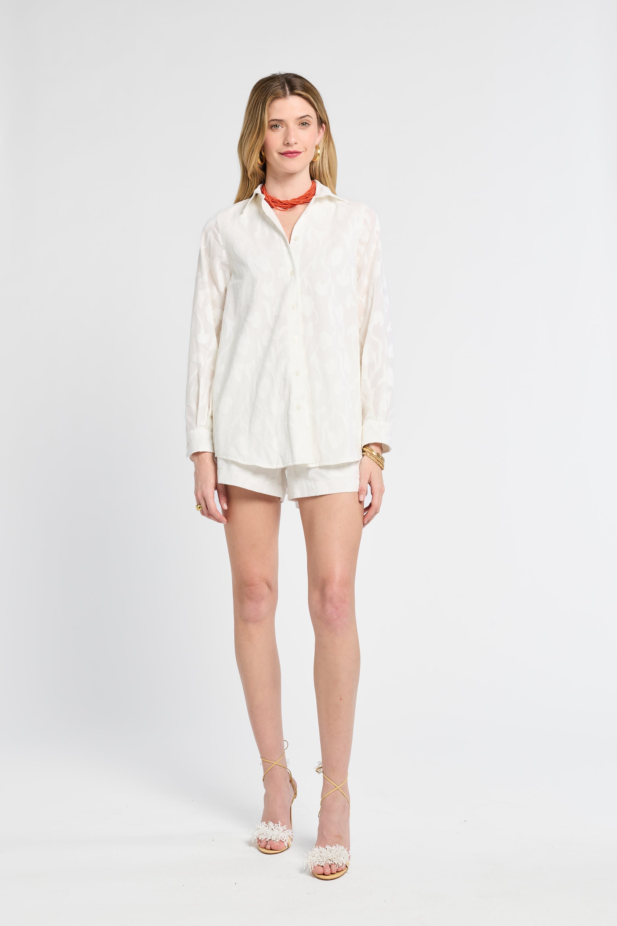 Woman wearing a white blouse and shorts on a white background