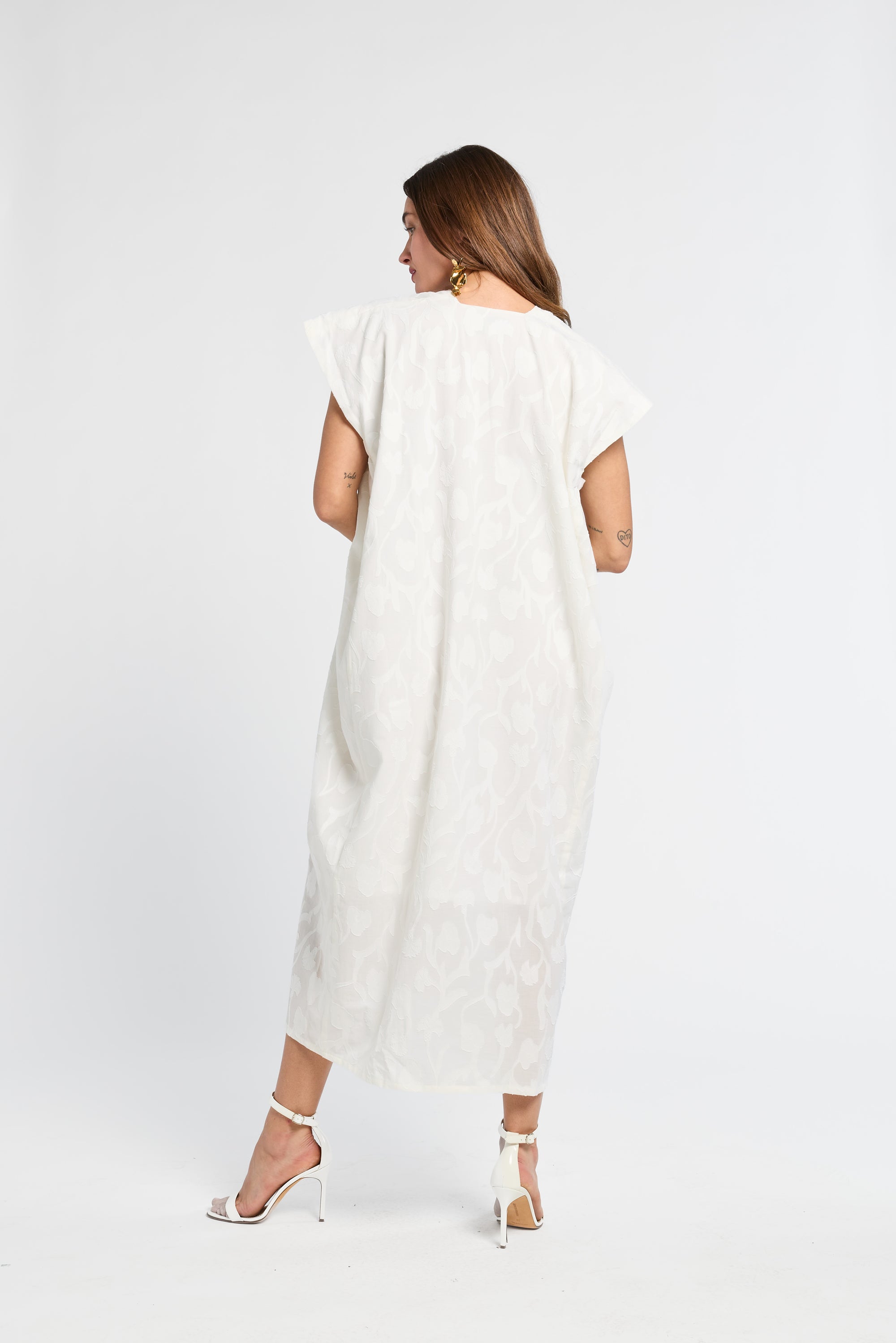 Woman wearing a long white dress on a white background
