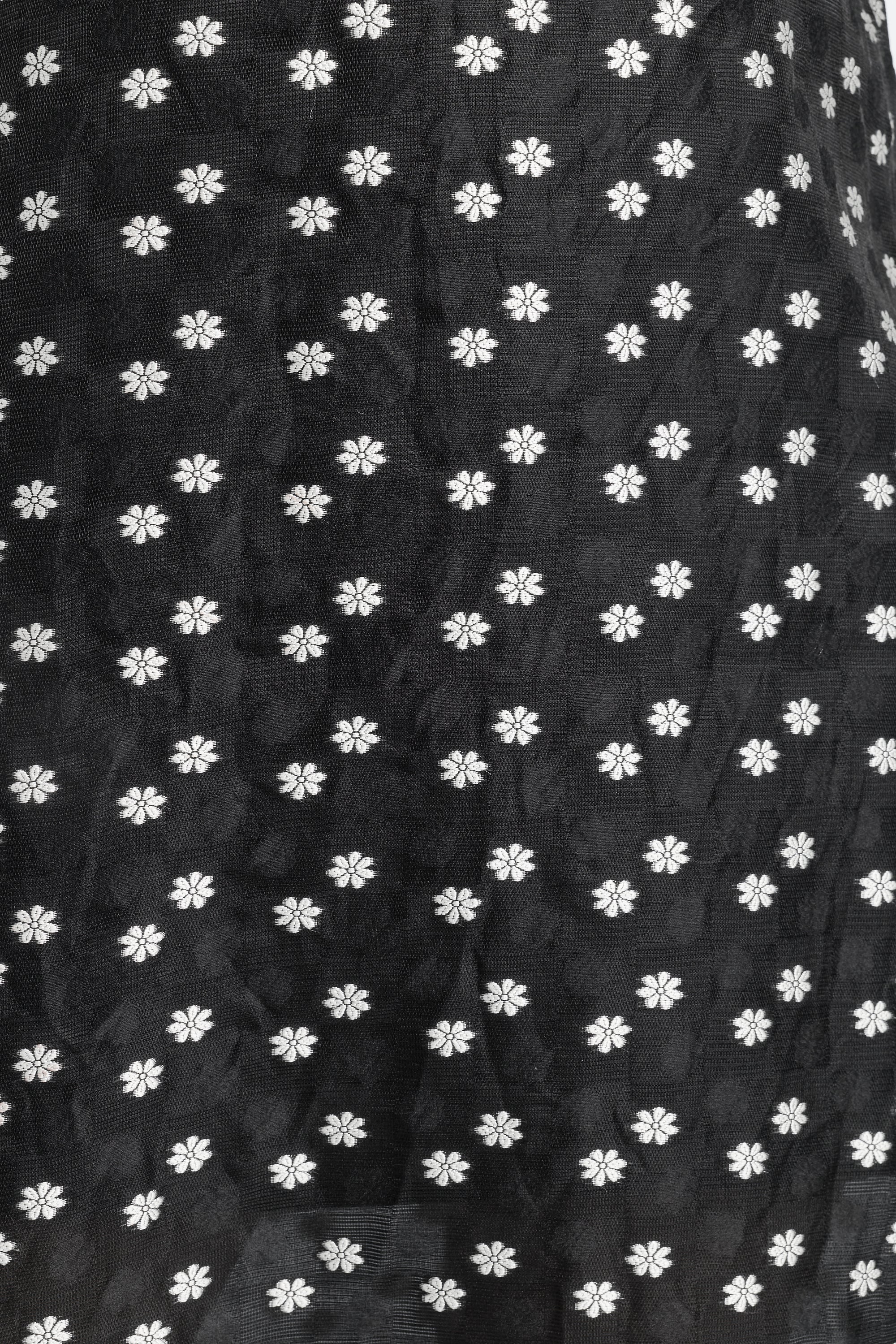 Close up image of sheer black fabric with small flower detailing