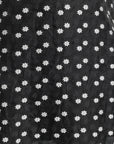 Close up image of sheer black fabric with small flower detailing