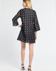 Woman modeling a sheer black dress with small white flowers on a white background