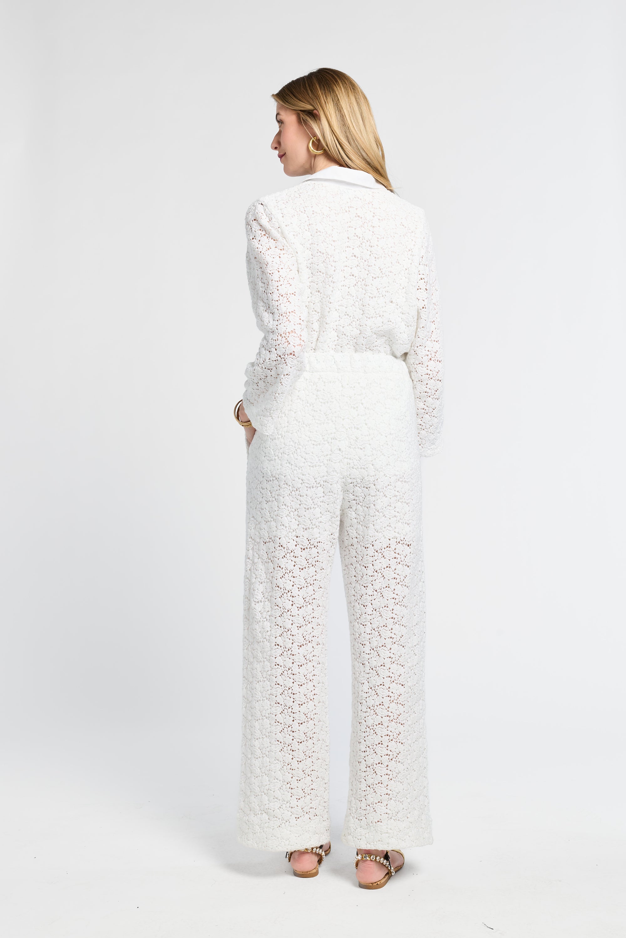 Woman wearing a white lace outfit on a white background