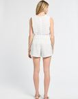 Woman wearing a pair of white lace shorts on a white background