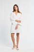 Woman wearing a v-neck white lace dress on a white background