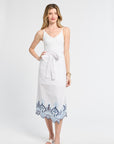 Woman wearing a white pareo with blue lace trim on a white background