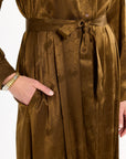 Close-up of the tied sash, pocket, buttons, and tonal floral texture of the Golden Umber Eleanor Shirt Dress, photographed against a plain white studio background.