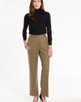 A woman modeling the Painter's Fleck Herringbone Ellis Pants with a black turtleneck and black heels, front view, photographed against a plain white studio background.
