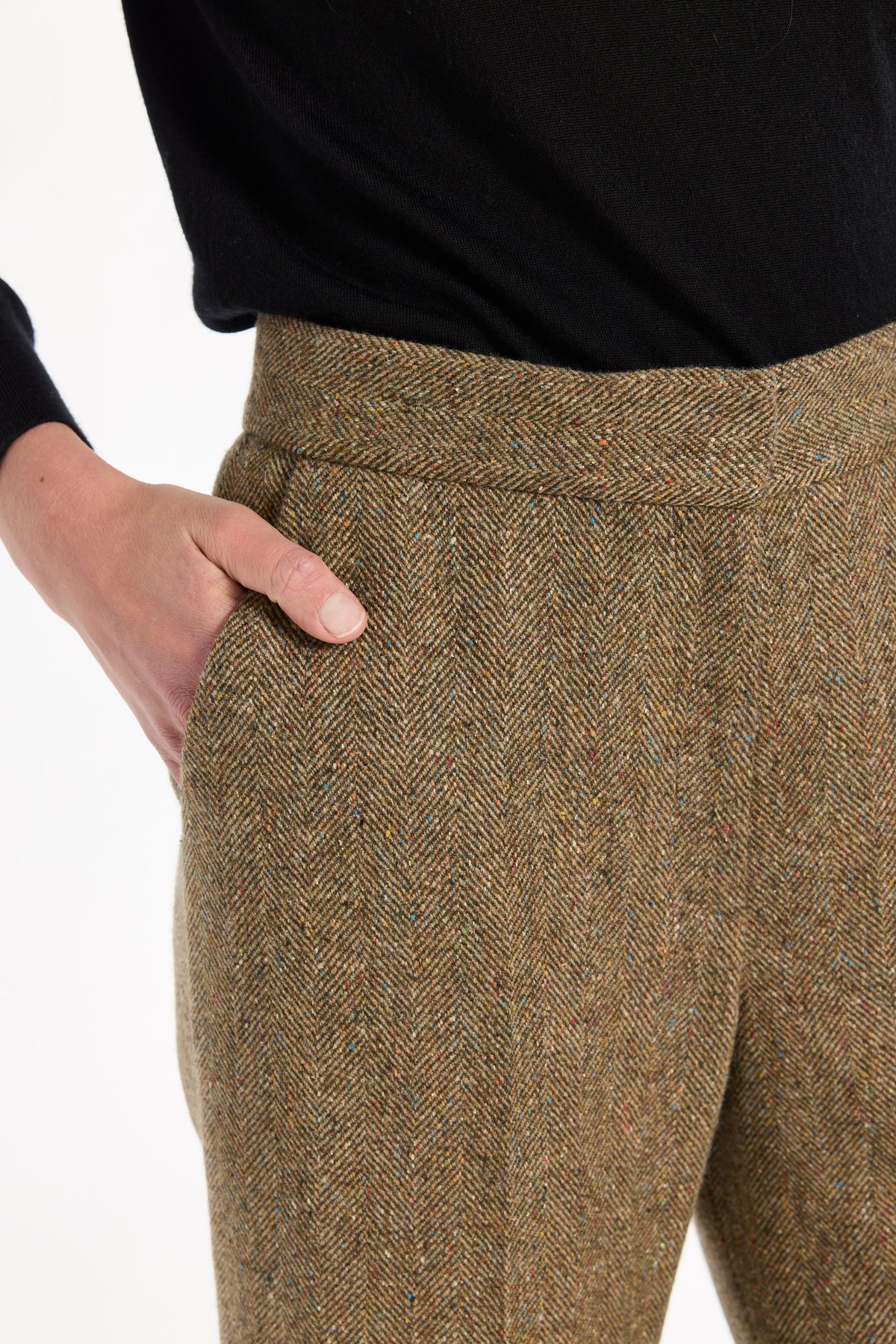 Close-up of the waistband, pocket, and flecked herringbone texture of the Ellis Pants, photographed against a plain white studio background.