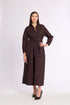Woman wearing a long brown dress with a belt on a white background