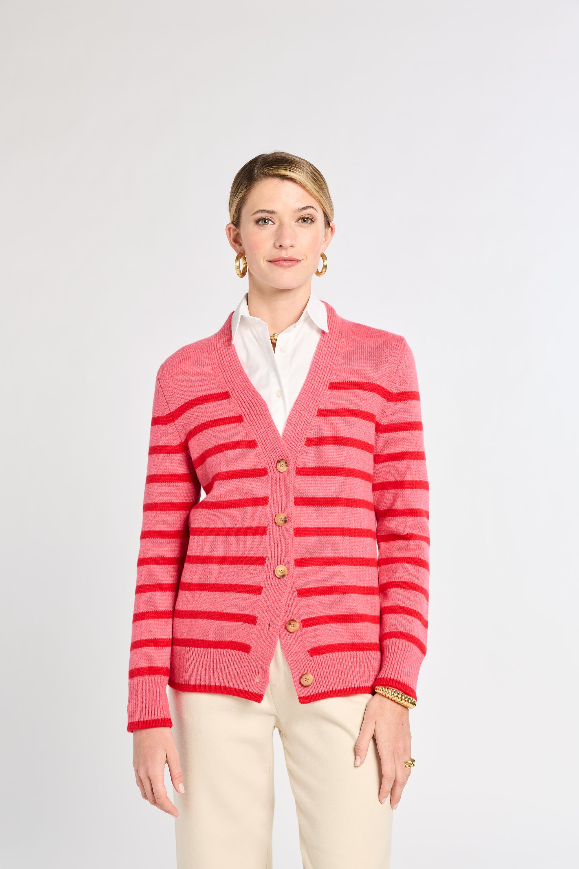 Woman wearing a pink striped cardigan on a white background