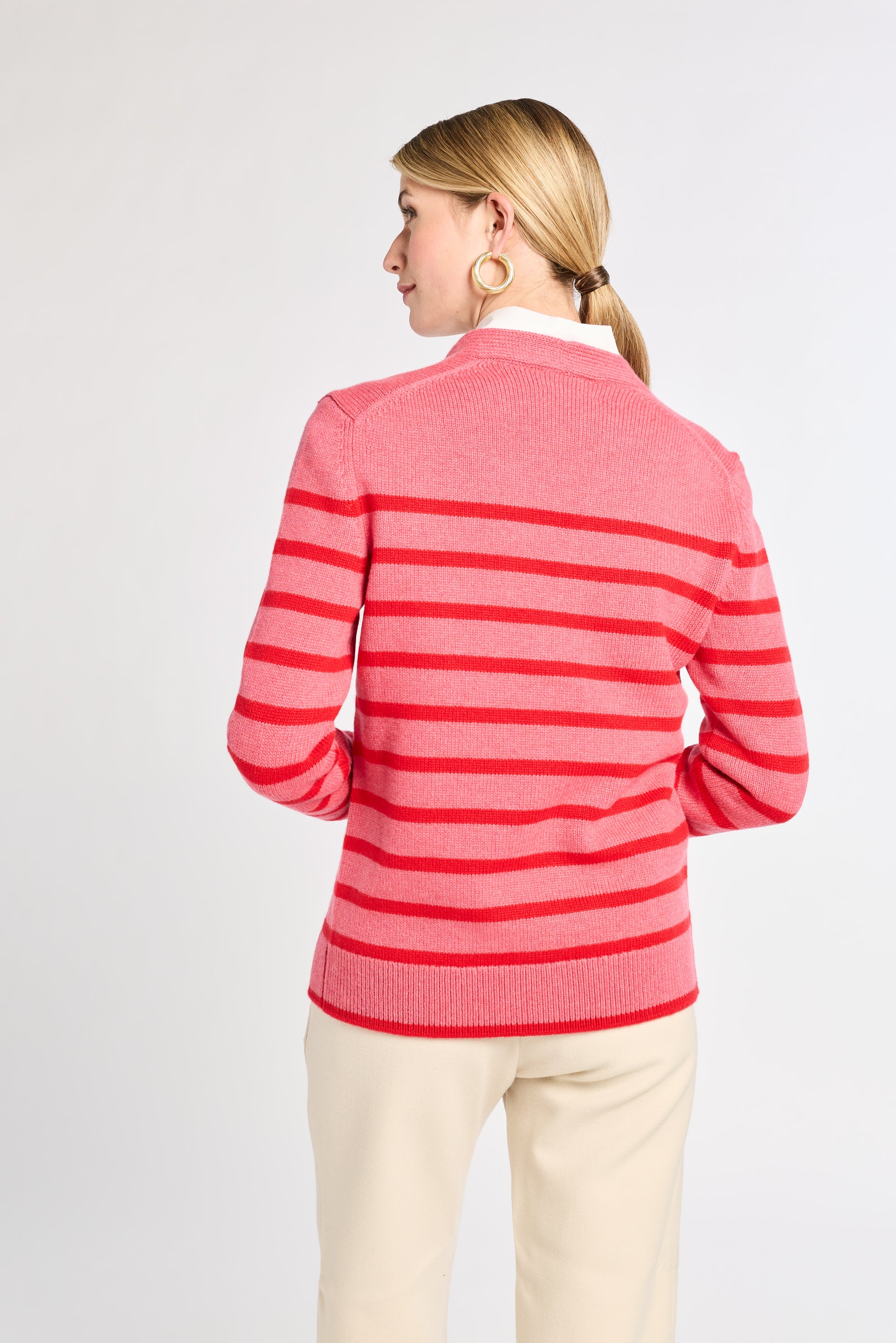 Woman wearing a pink and red striped sweater on a white background