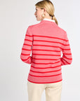Woman wearing a pink and red striped sweater on a white background