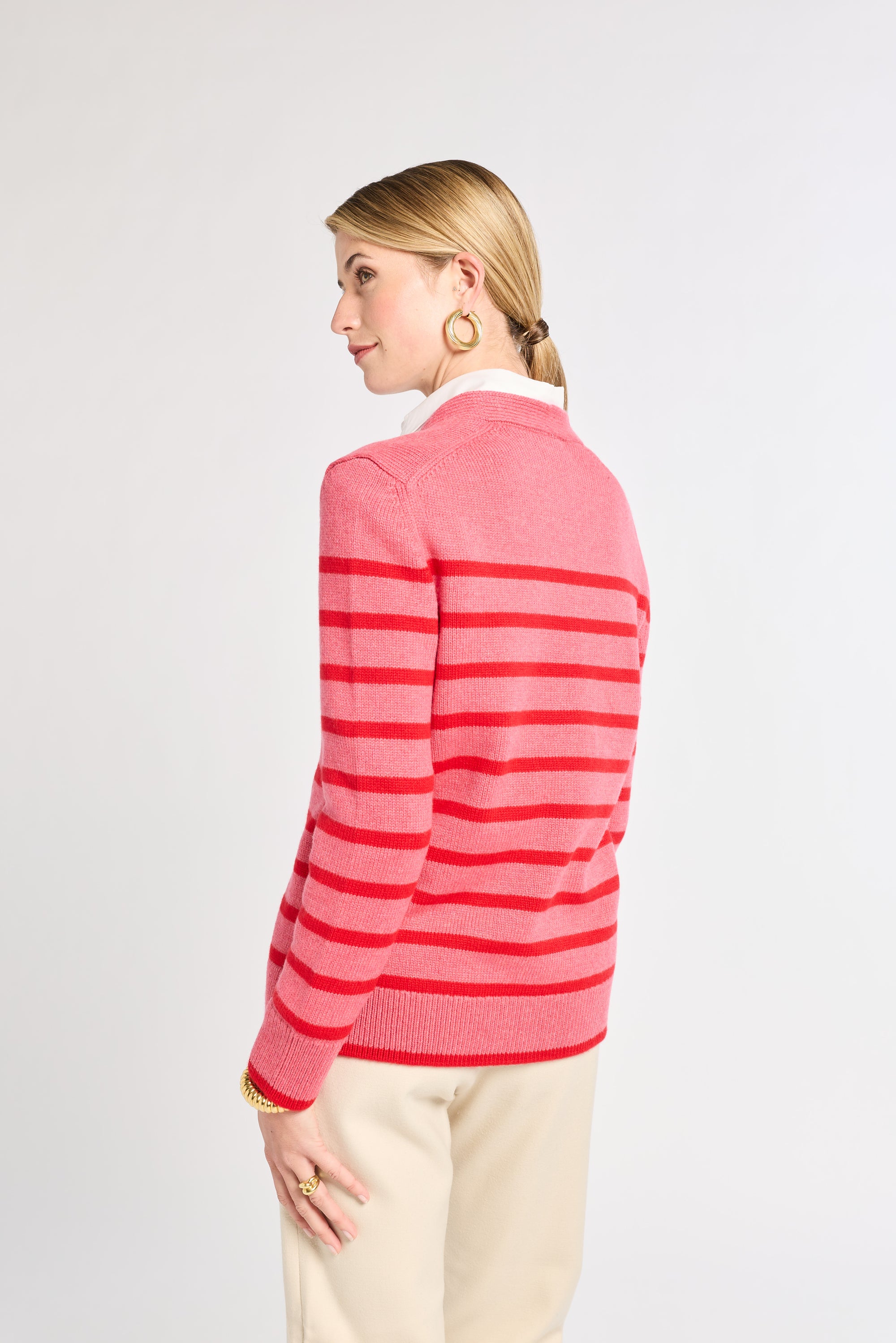 Woman wearing a pink striped sweater on a white background