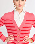 Woman wearing a pink striped cardigan with gold buttons on a white background