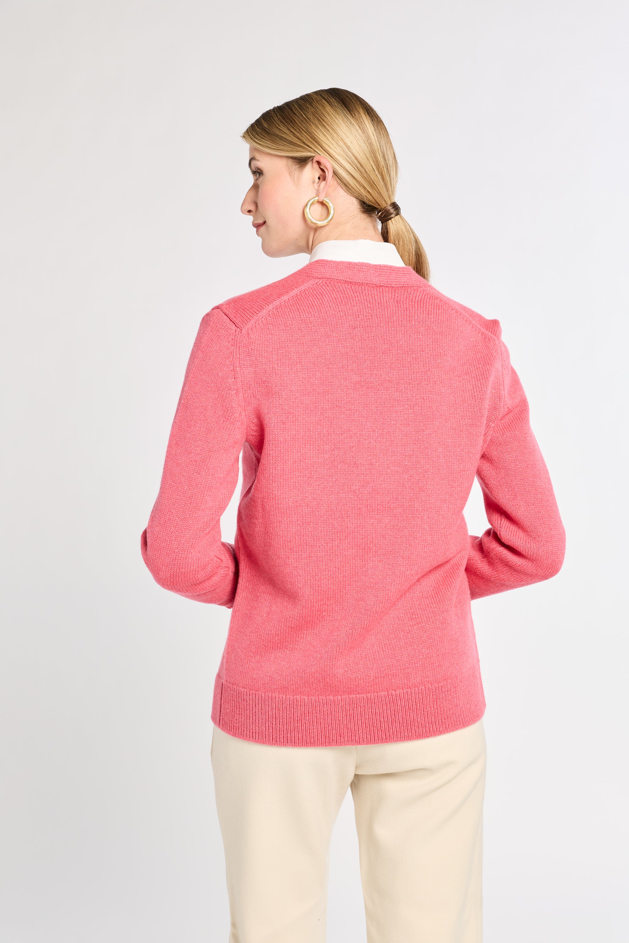 Woman wearing a pink sweater on a white background