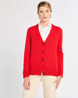 Woman wearing a red cardigan over a white shirt on a light gray background
