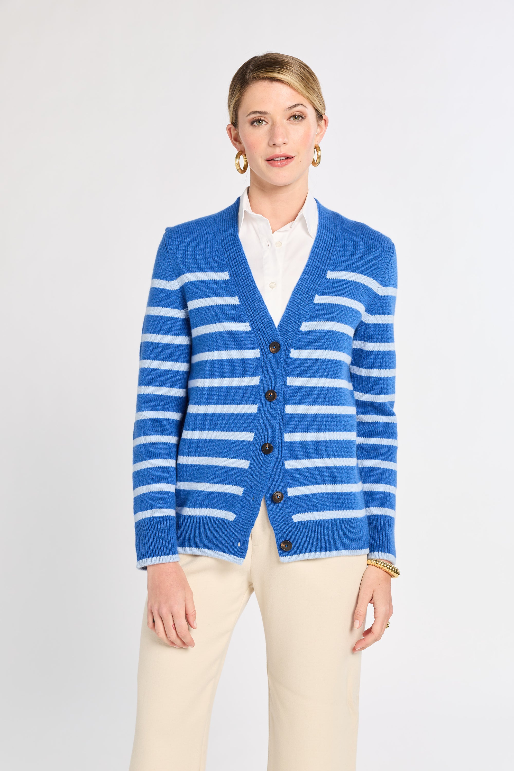Woman wearing a blue and white striped cardigan on a light gray background