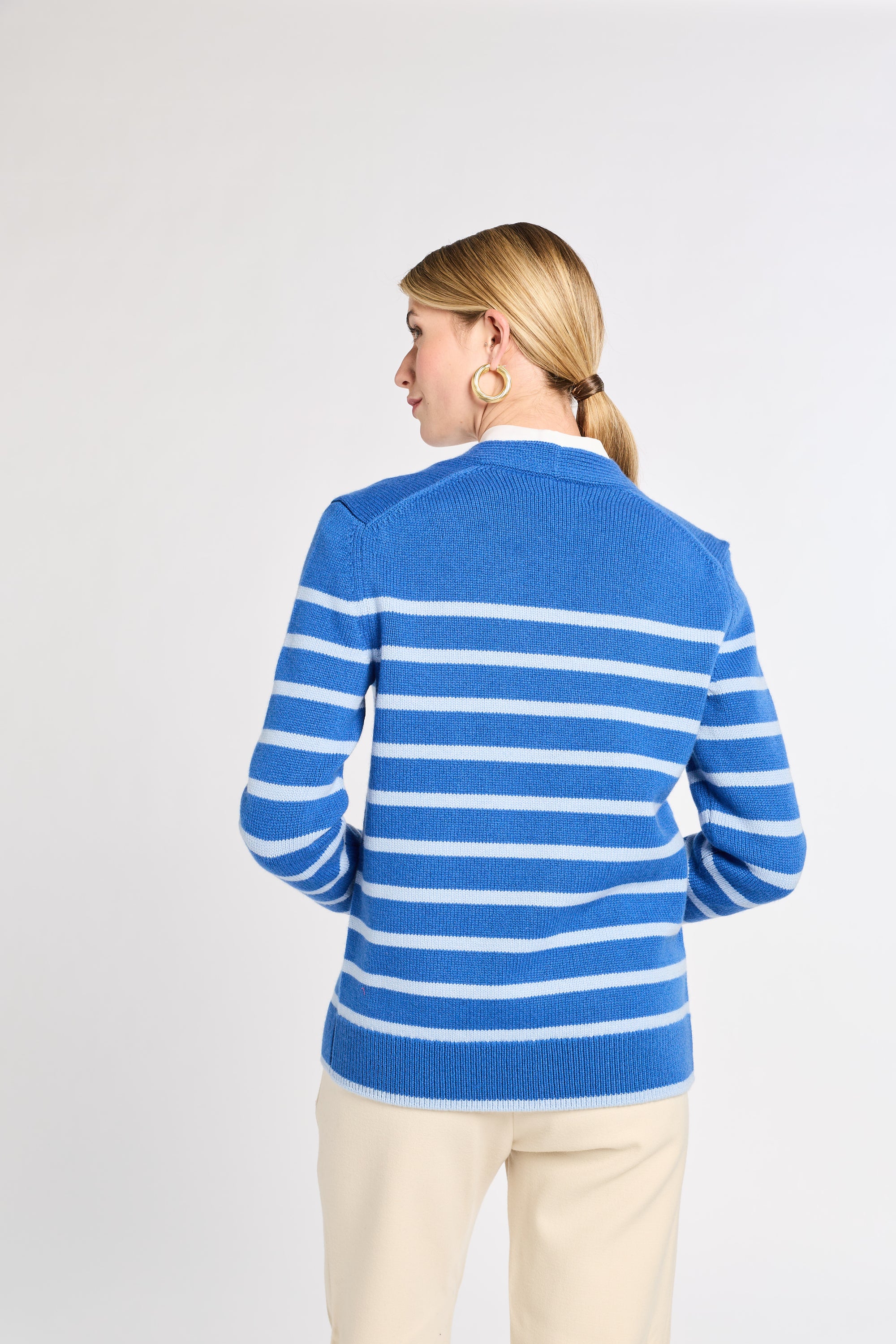 Woman wearing a blue and white striped sweater on a plain background