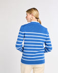 Woman wearing a blue and white striped sweater on a plain background