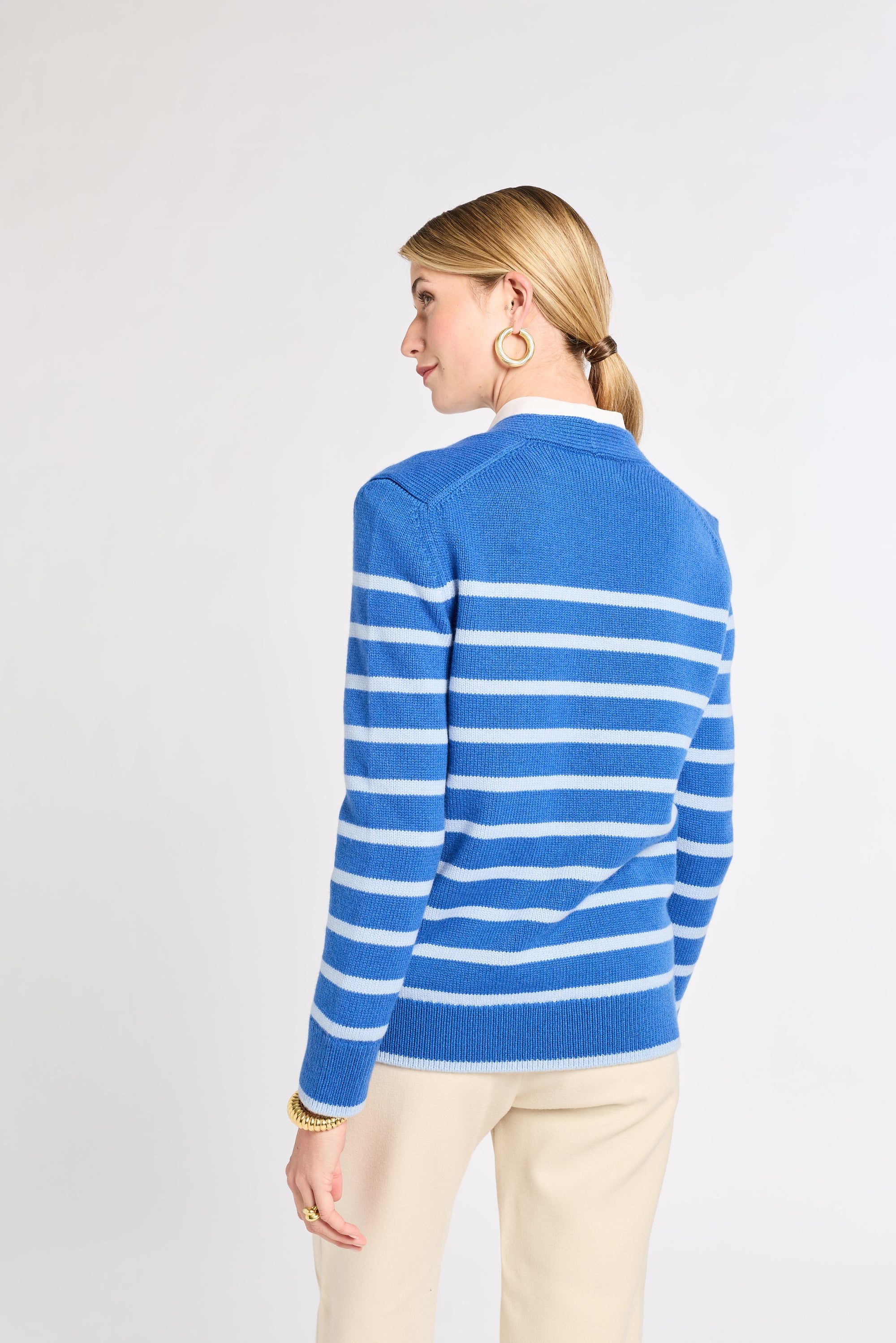 Woman wearing a blue and white striped sweater on a light gray background