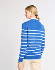 Woman wearing a blue and white striped sweater on a light gray background