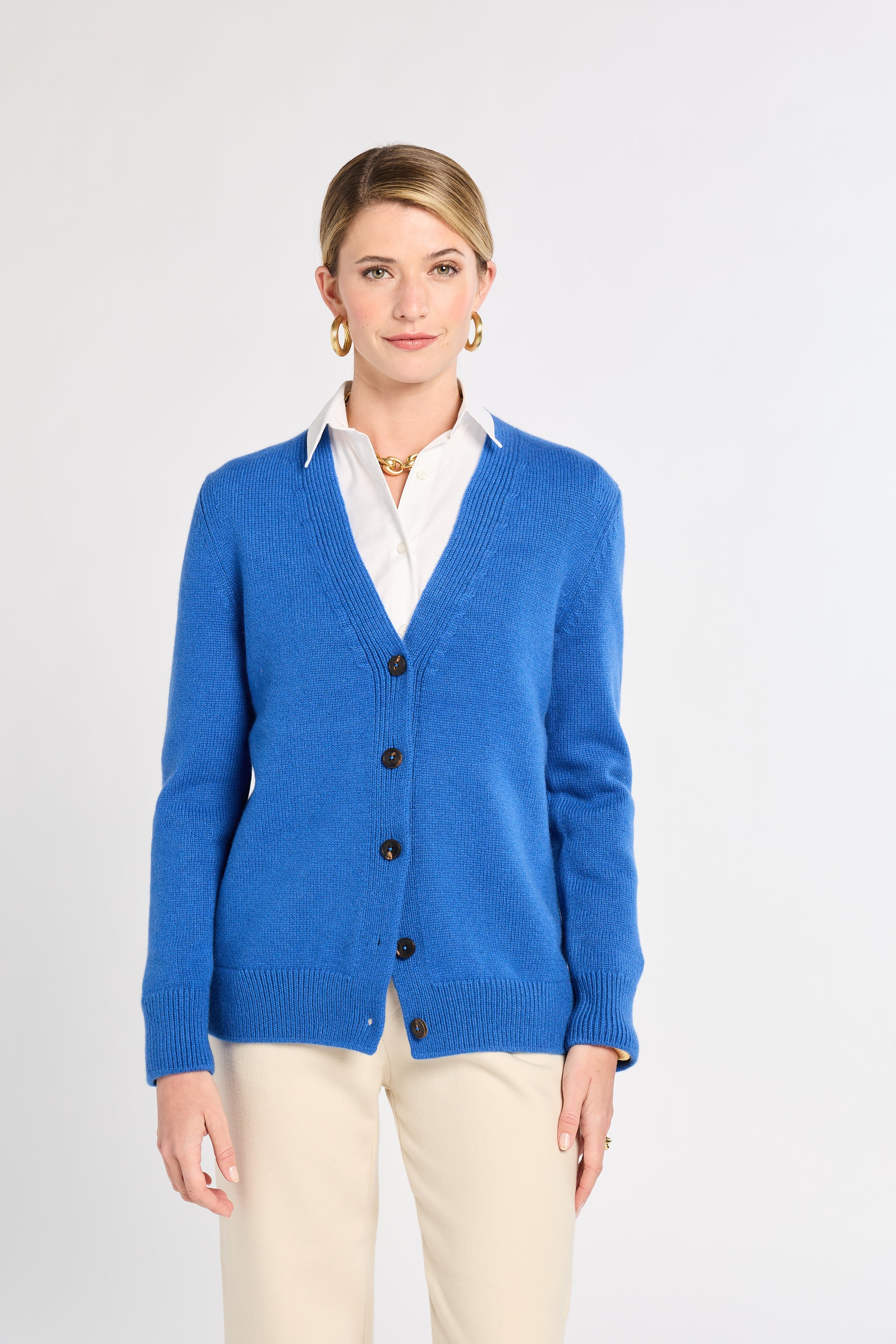 Woman in blue cardigan with white background. 