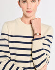 Woman wearing a cream and navy striped sweater on a white background