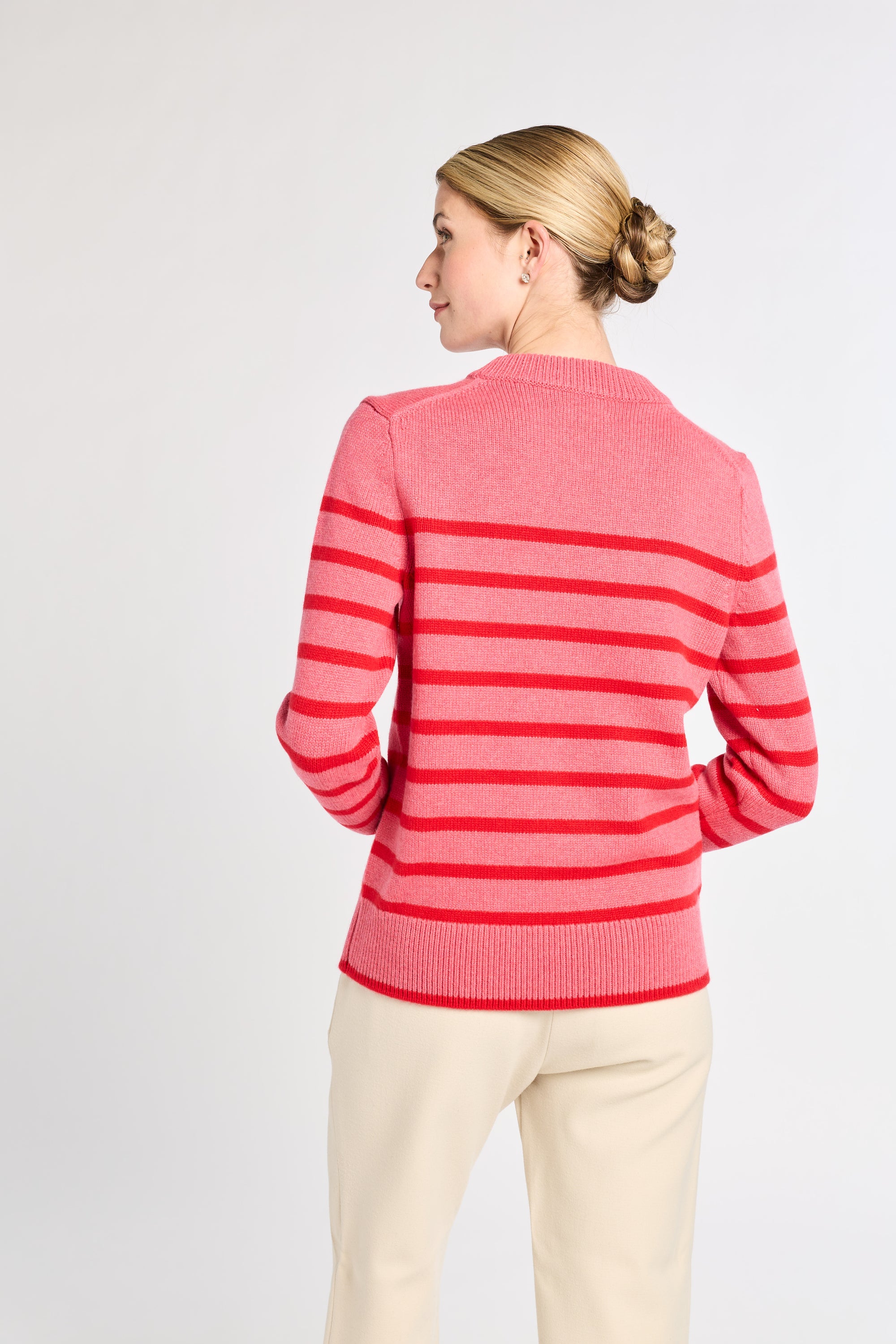 Woman wearing a pink striped sweater on a white background
