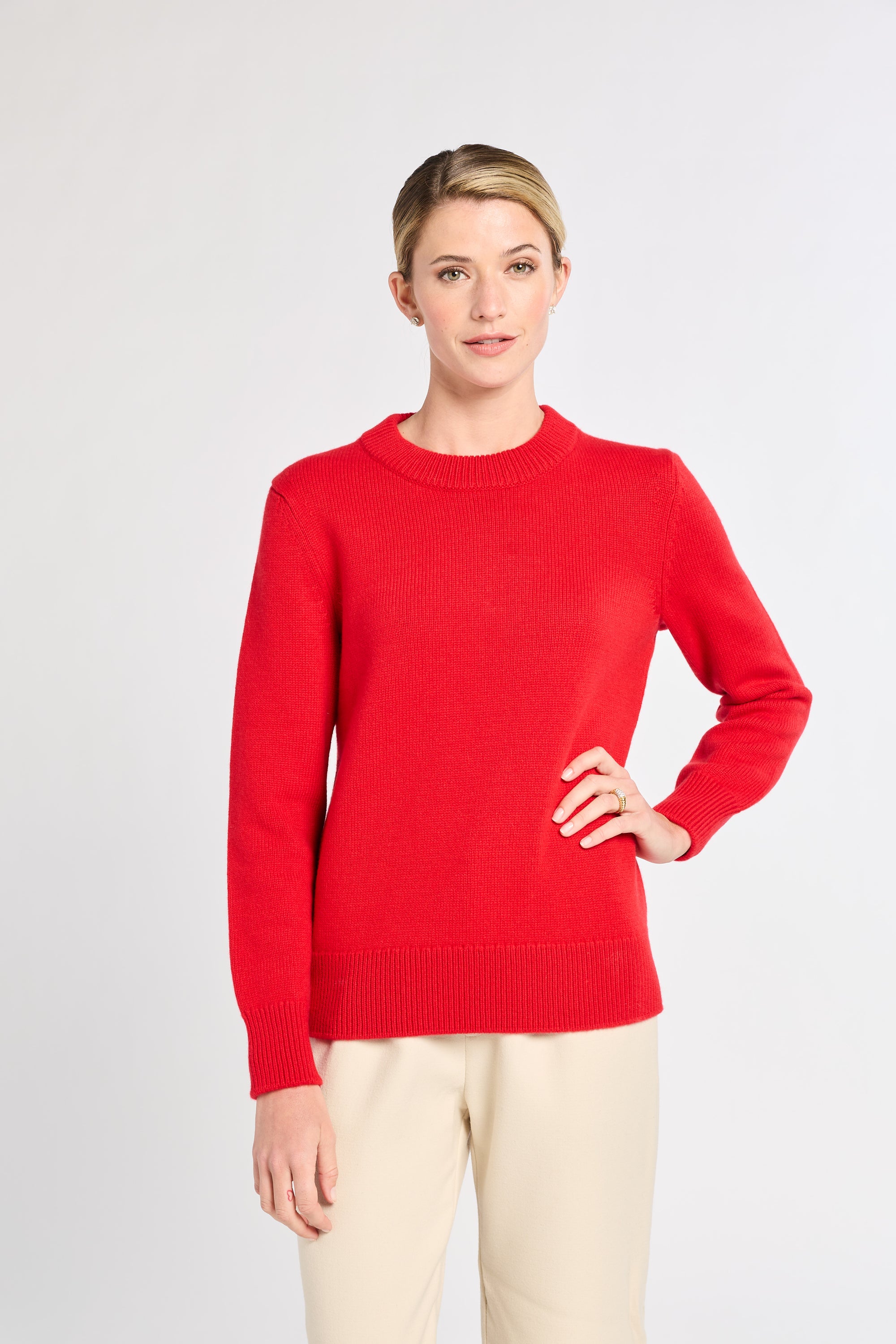 Woman wearing a red sweater on a light gray background