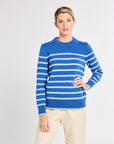 Woman with cobalt with light blue stripe sweater with white background. 