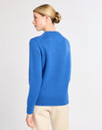 Woman wearing a blue sweater on a light gray background