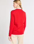 Person wearing a red sweater and beige pants on a white background
