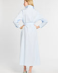 Woman wearing a light blue striped dress on a white background